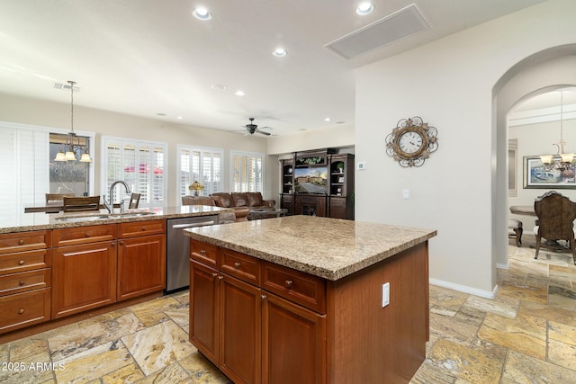 kitchen with sink, dishwasher, ceiling fan with notable chandelier, hanging light fixtures, and a kitchen island