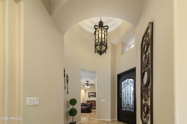 entrance foyer with ceiling fan with notable chandelier