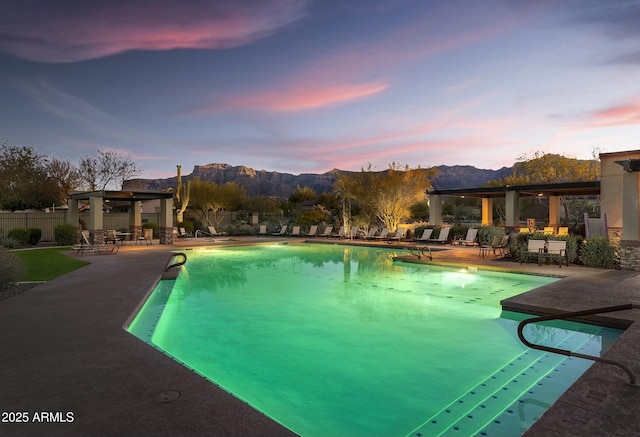 pool at dusk with a patio, a gazebo, and a mountain view