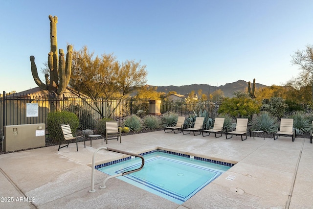 view of swimming pool featuring a community hot tub, a patio, and a mountain view