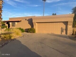 pueblo revival-style home featuring a garage