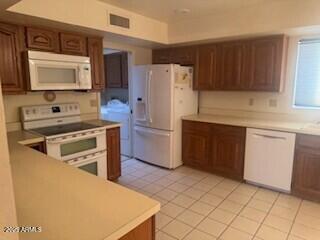 kitchen with light tile patterned floors and white appliances