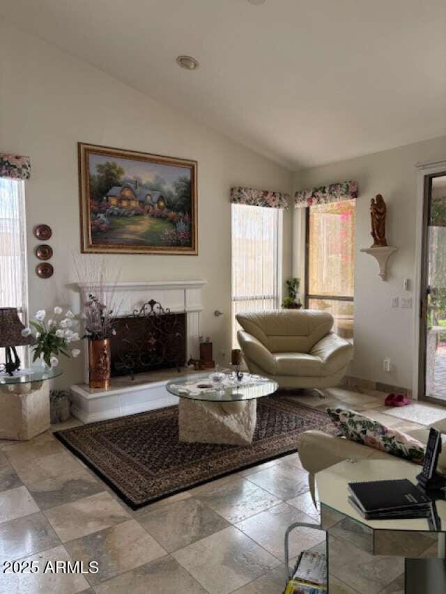 living area featuring lofted ceiling and healthy amount of natural light