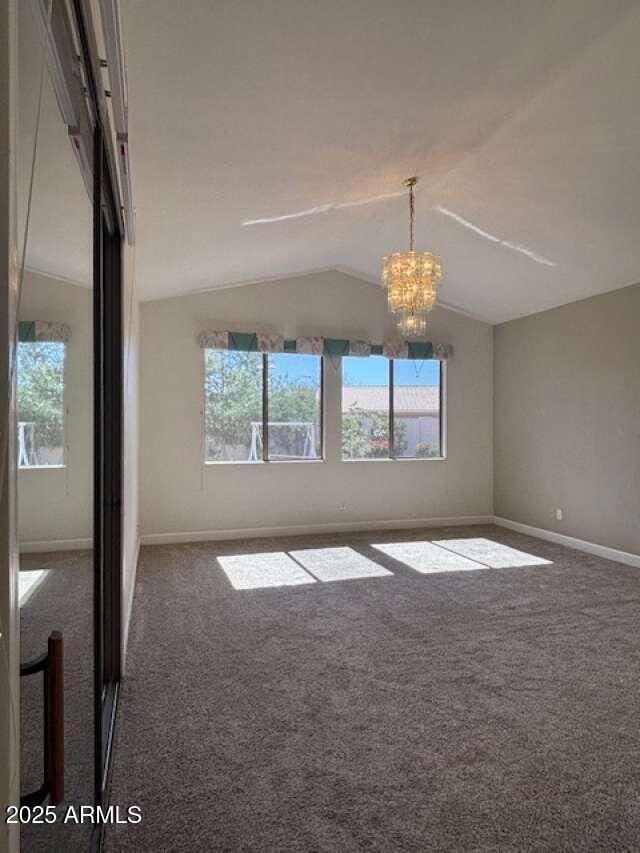 empty room with healthy amount of natural light, carpet floors, and lofted ceiling