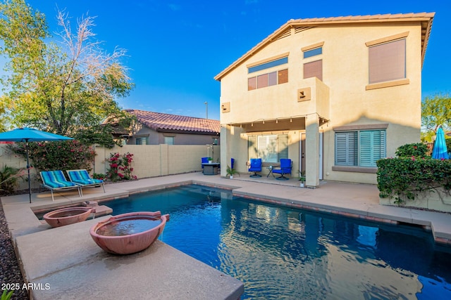 rear view of property featuring a patio area, an outdoor fire pit, stucco siding, and a fenced backyard