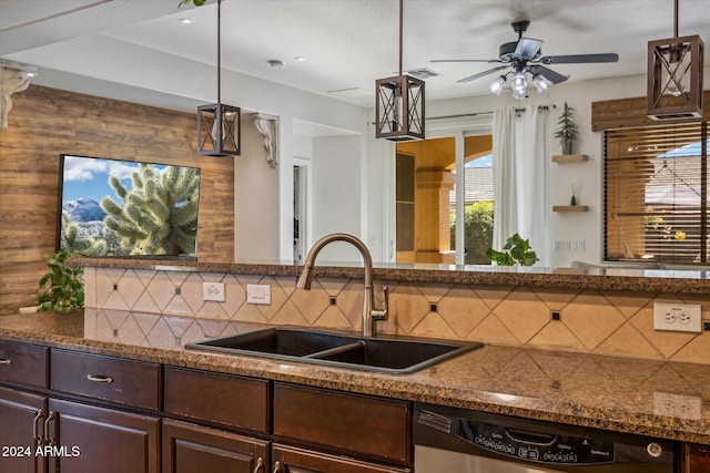 kitchen featuring stainless steel dishwasher, decorative light fixtures, decorative backsplash, and sink