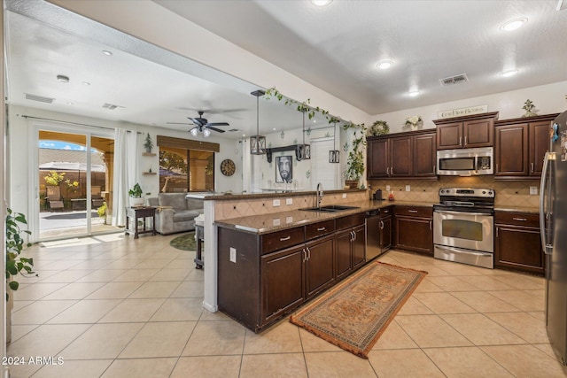 kitchen with backsplash, kitchen peninsula, stainless steel appliances, and light tile patterned floors