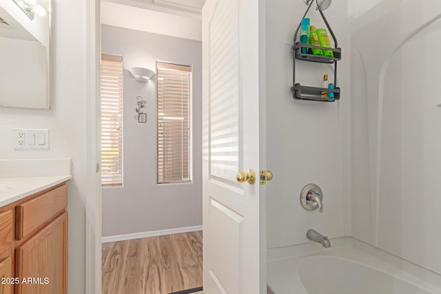 full bathroom with wood finished floors, visible vents, bathing tub / shower combination, vanity, and baseboards