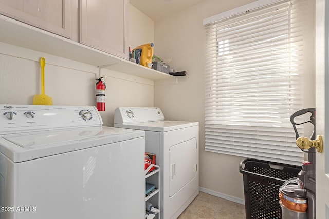 washroom featuring baseboards, cabinet space, and washer and dryer