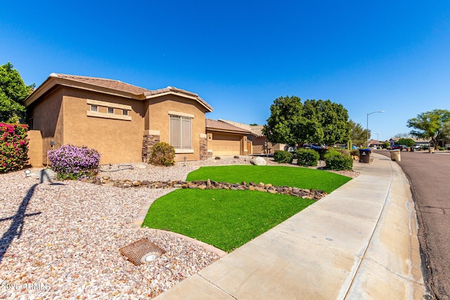 view of front of property featuring a front yard, a tiled roof, stone siding, and stucco siding