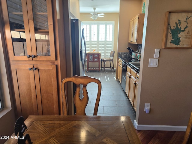 kitchen featuring sink, ceiling fan, stainless steel refrigerator with ice dispenser, and black dishwasher