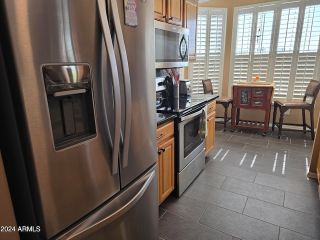 kitchen featuring appliances with stainless steel finishes and dark tile flooring