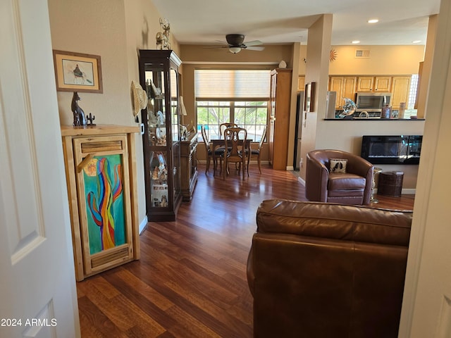 living room with ceiling fan and dark wood-type flooring