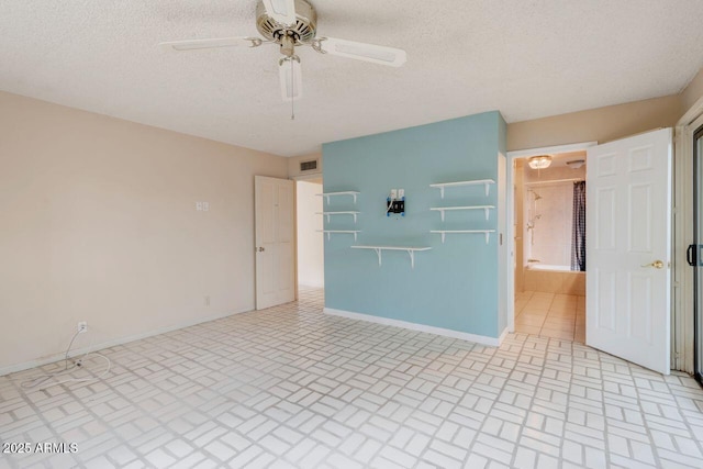 spare room featuring visible vents, baseboards, a textured ceiling, and ceiling fan