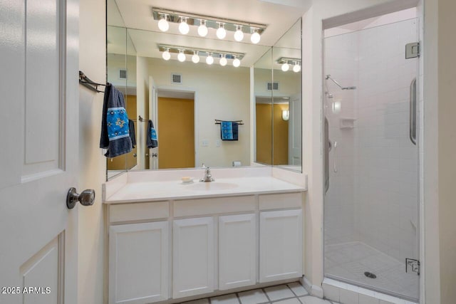 bathroom featuring vanity, a shower stall, and visible vents