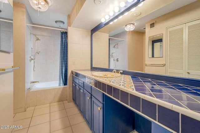 bathroom with tile patterned flooring, visible vents, vanity, and tiled shower / bath combo