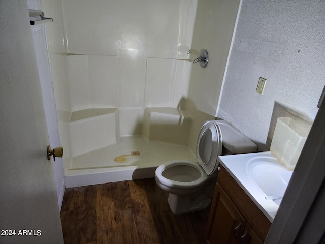 bathroom featuring a shower, hardwood / wood-style floors, vanity, and toilet