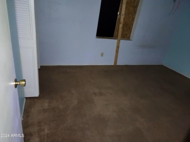 unfurnished room with dark colored carpet