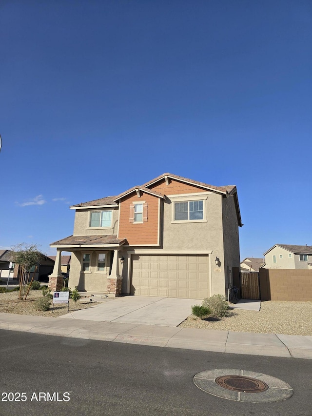 view of front of house featuring driveway, an attached garage, fence, and stucco siding