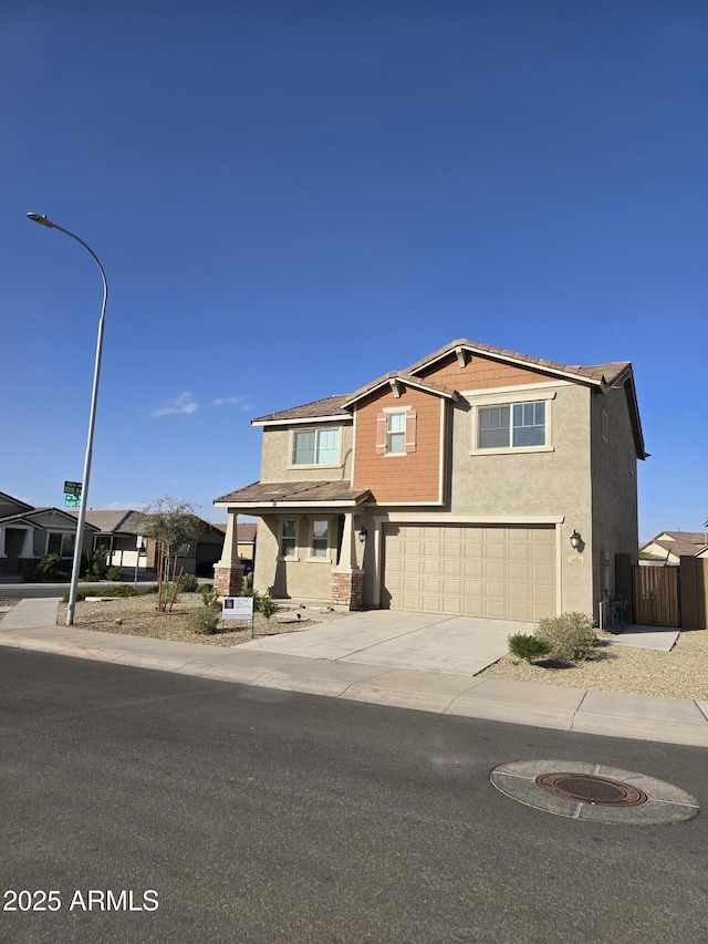 view of front of home featuring concrete driveway, fence, an attached garage, and stucco siding