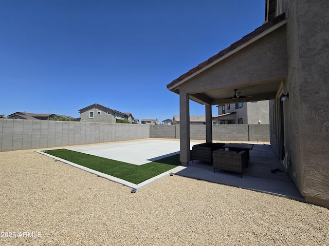 view of yard with a fenced backyard, ceiling fan, and a patio