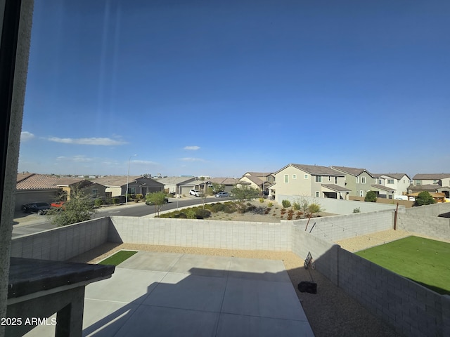 view of patio / terrace featuring a fenced backyard and a residential view