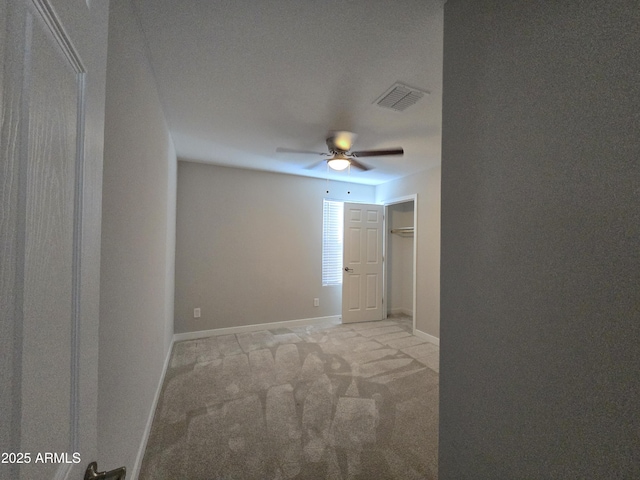 unfurnished room featuring light carpet, baseboards, visible vents, and ceiling fan