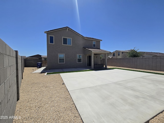 back of property featuring a fenced backyard, a patio, and stucco siding