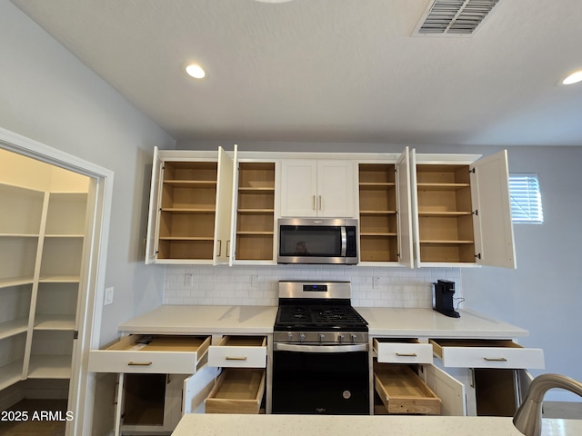 kitchen featuring open shelves, appliances with stainless steel finishes, visible vents, and decorative backsplash