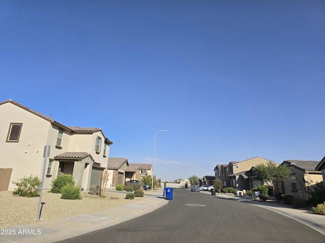 view of street featuring a residential view, sidewalks, and street lights