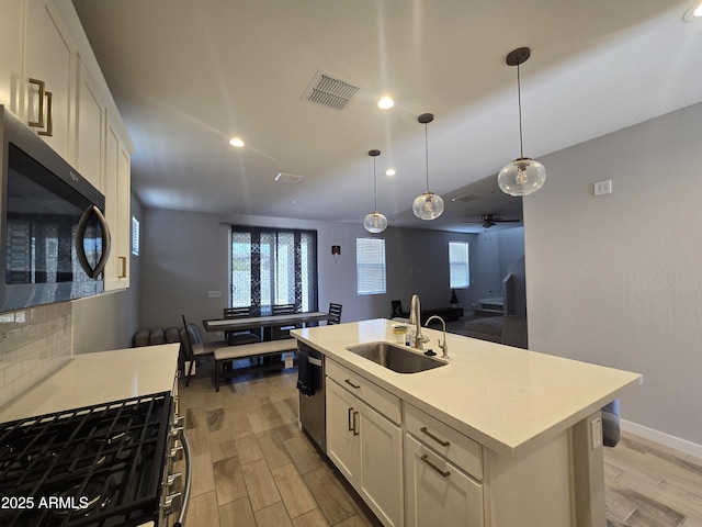 kitchen with dishwasher, visible vents, light countertops, and a sink