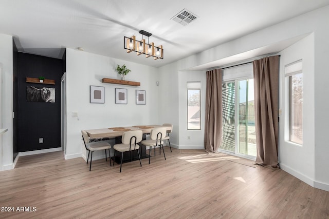 dining area with a chandelier and light hardwood / wood-style floors