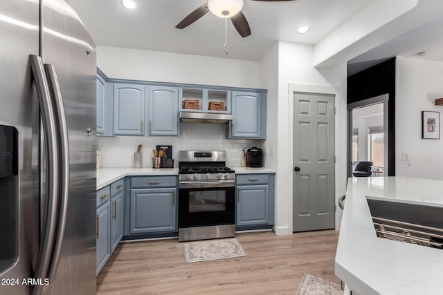 kitchen featuring ceiling fan, decorative backsplash, range hood, appliances with stainless steel finishes, and light hardwood / wood-style floors