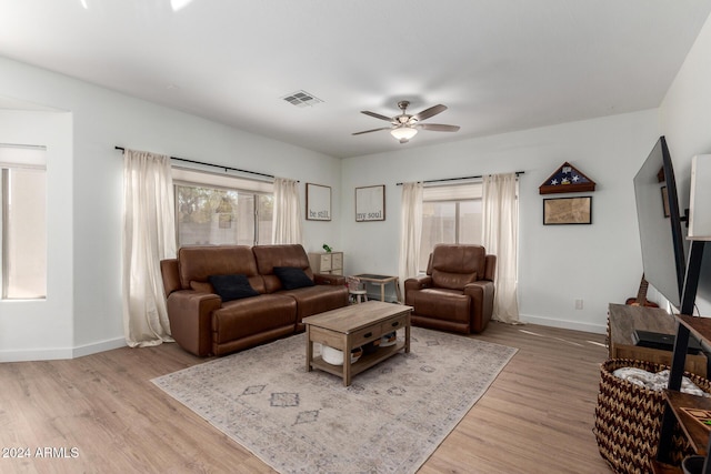 living room featuring light wood-type flooring, plenty of natural light, and ceiling fan