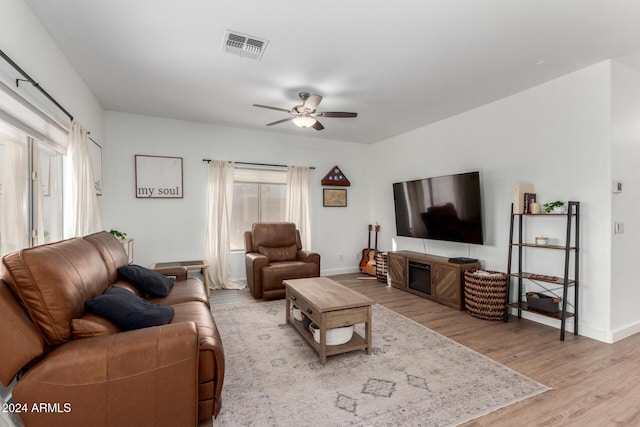 living room with ceiling fan and light wood-type flooring