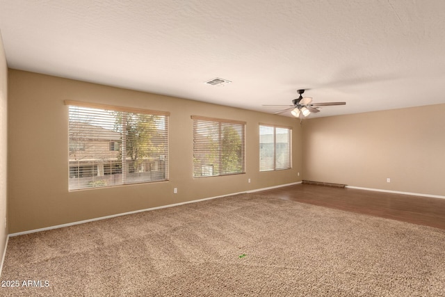 unfurnished room with ceiling fan, carpet, and a textured ceiling