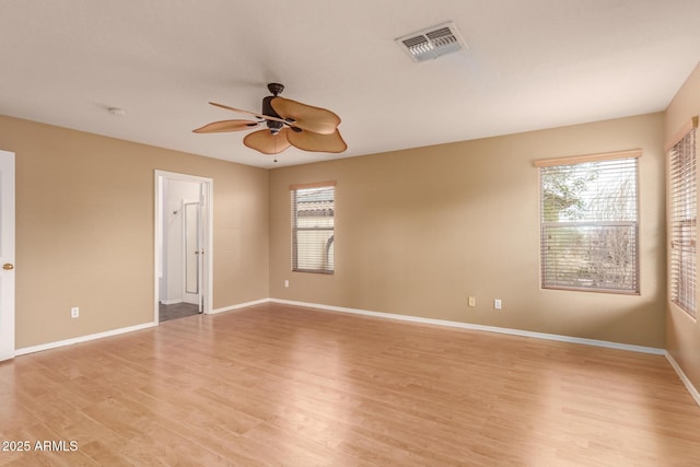 empty room with ceiling fan and light hardwood / wood-style floors