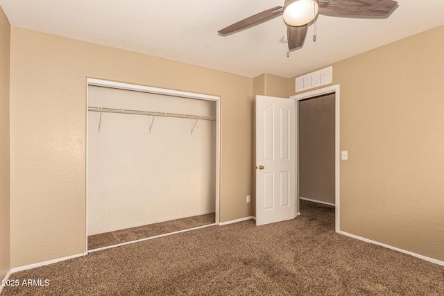 unfurnished bedroom featuring ceiling fan, a closet, and dark carpet