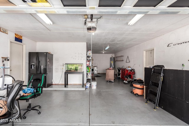 garage with a garage door opener and black fridge with ice dispenser