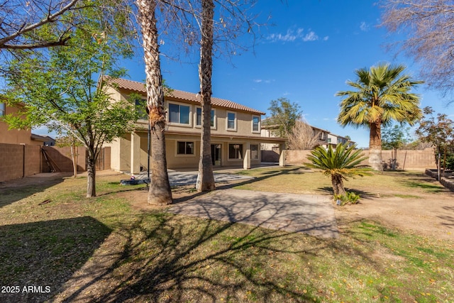 rear view of property featuring a lawn and a patio