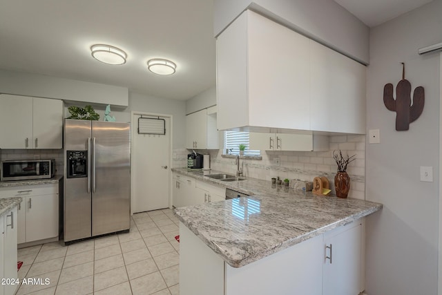 kitchen featuring sink, decorative backsplash, appliances with stainless steel finishes, light stone counters, and white cabinetry