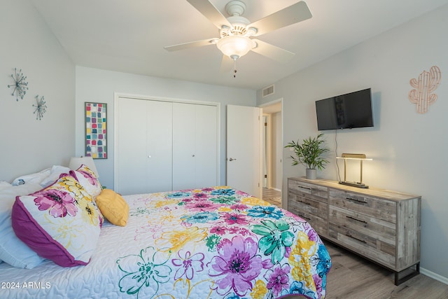 bedroom with a closet, hardwood / wood-style flooring, and ceiling fan