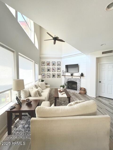10229 N 12th Ct Unit 1, Phoenix, AZ 85020 - living room with plenty of natural light, a brick fireplace, wood finished floors, ceiling fan, and a towering ceiling