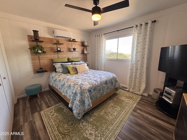 251 W 8th St, Ajo, AZ 85321 - bedroom with a wall mounted air conditioner, wood finished floors, a ceiling fan, and baseboards