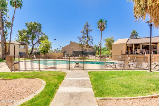 community pool featuring fence, a patio, and a lawn