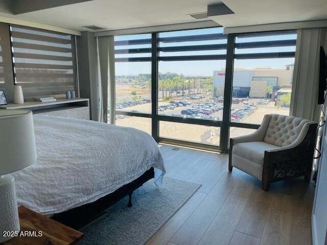 bedroom featuring a wall of windows and wood-type flooring