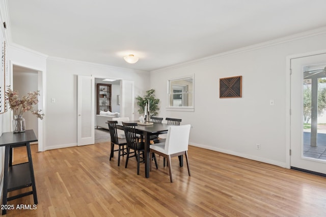 dining area with crown molding and light hardwood / wood-style flooring