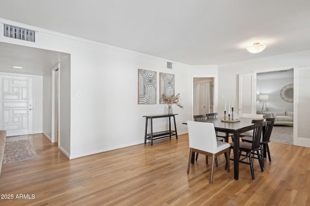 dining room featuring hardwood / wood-style flooring and ornamental molding