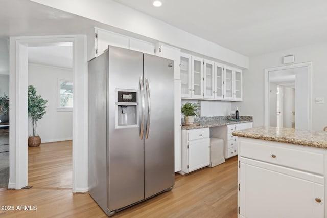 kitchen featuring light hardwood / wood-style flooring, white cabinets, light stone counters, and stainless steel fridge with ice dispenser