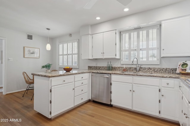 kitchen with sink, white cabinetry, stainless steel dishwasher, kitchen peninsula, and pendant lighting